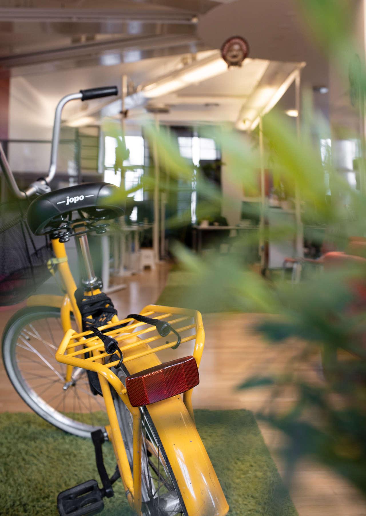 Keltainen Jopo-polkupyörä Poutapilven toimistolla.